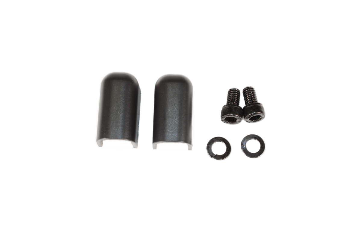 A set of black battery input terminal covers, screws, and washers against a white background